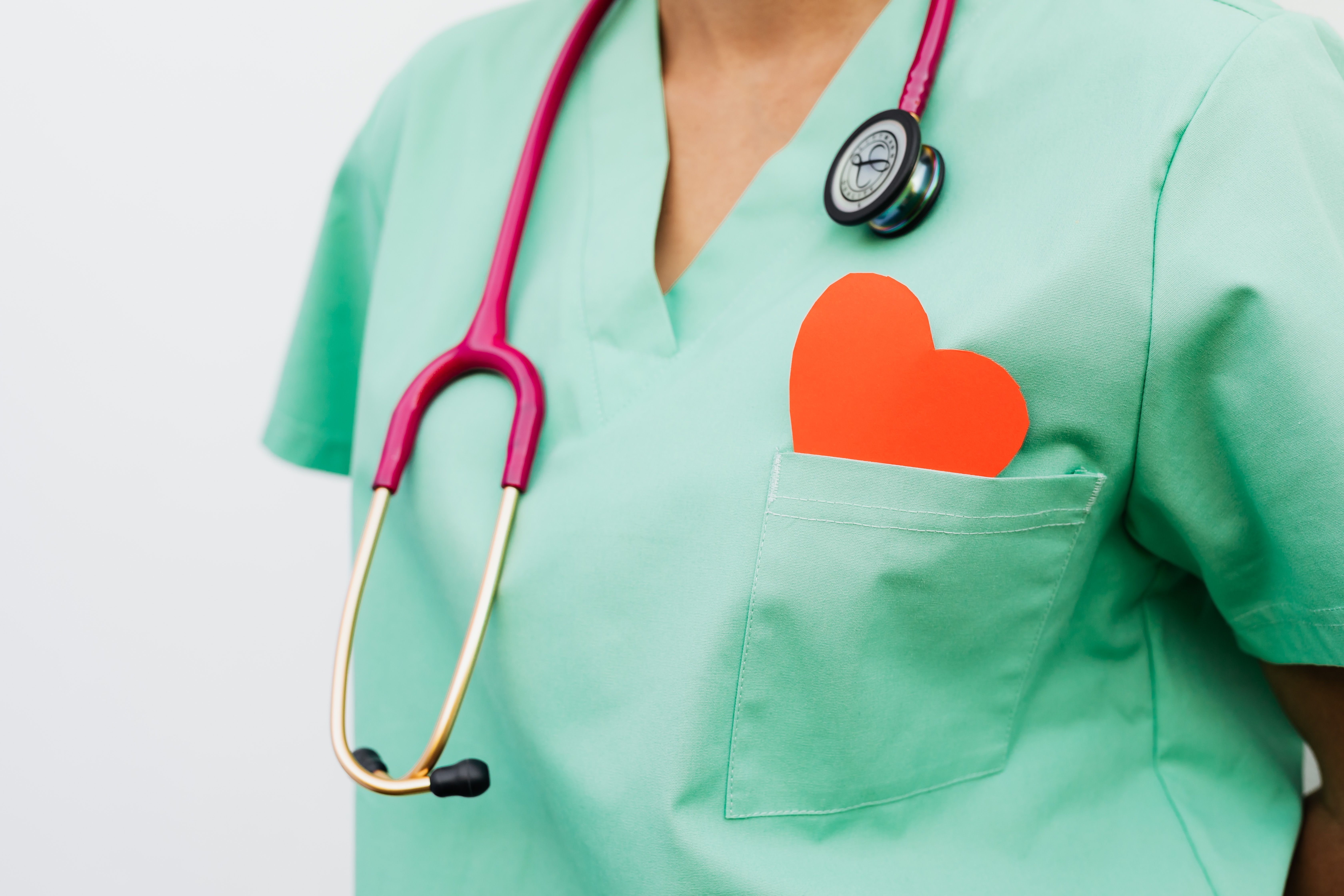 Healthcare professional with a stethoscope and red heart symbol representing cardiovascular care